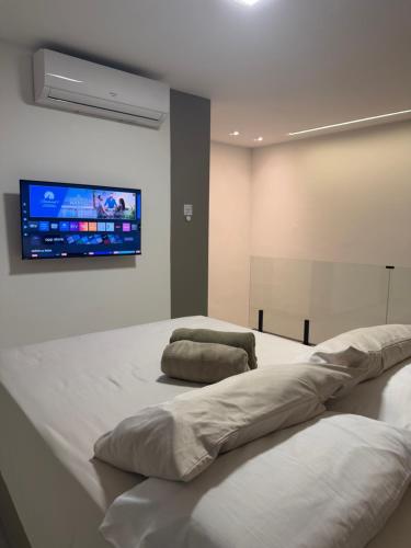 a room with a large bed with a tv on the wall at Duplex Coité in Conceição do Coité