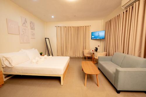 a room with a bed and a couch and a table at Cozypod Rentals in Sagcahan