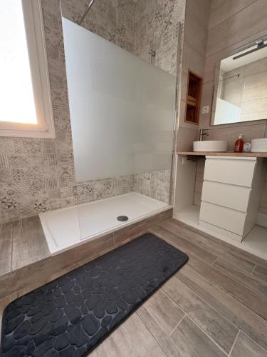 a bathroom with a shower and a black rug at Spacious, bright and comfortable bedrooms in Lannemezan