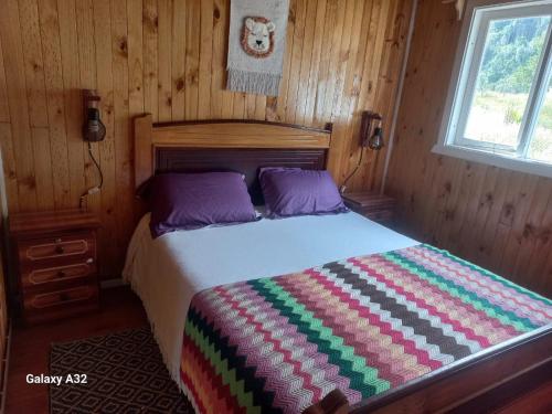 a bedroom with a bed in a wooden room at Cabaña Terraza del Yates in Puerto del Yate