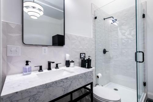 a white bathroom with a sink and a mirror at Hollyhock Suite 409 in Louisville