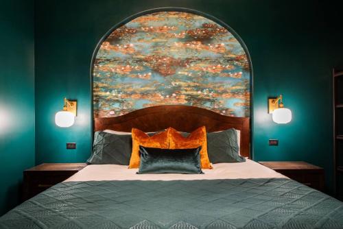 a bedroom with a bed with a large painting on the wall at Hollyhock Suite 411 in Louisville