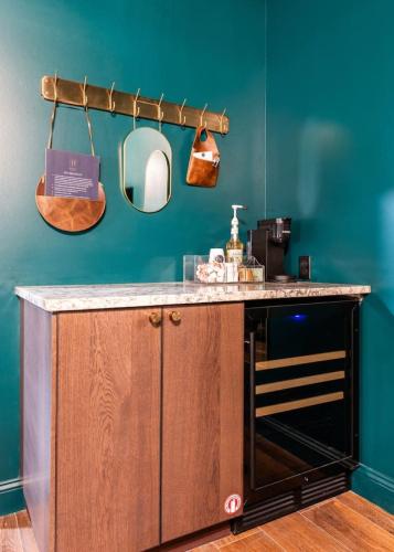 a kitchen with a counter with a sink and a mirror at Hollyhock Suite 411 in Louisville