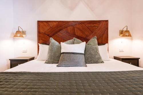 a bedroom with a bed with a wooden headboard and pillows at Hollyhock Suite 407 in Louisville