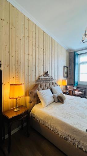 a bedroom with a bed with a wooden wall at Casa da Freiria in Ponte de Lima