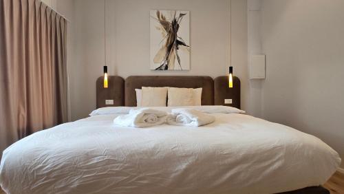 a bedroom with a large white bed with towels on it at Apartment Local Uetendorf in Uetendorf