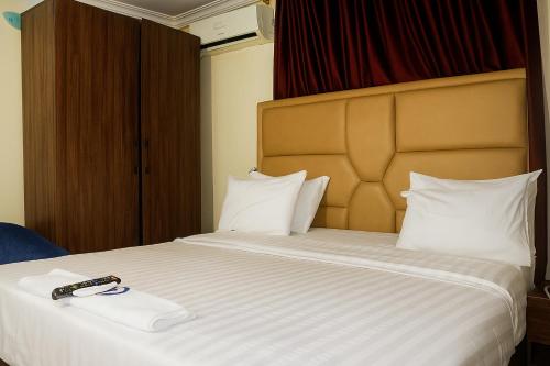 a hotel room with a bed with a remote control on it at GTKATE Paradise Hotel in Ikeja