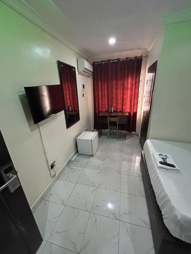 a room with a bed and a table in it at GTKATE Paradise Hotel in Ikeja