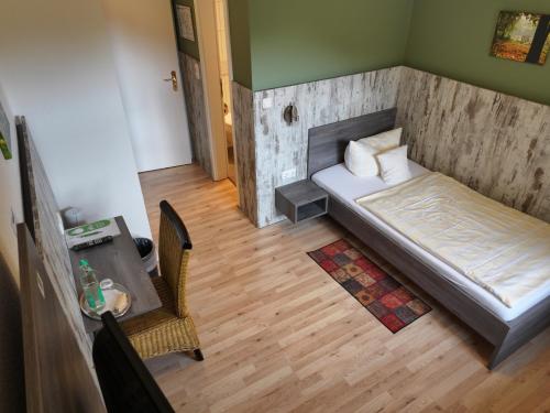 a bedroom with a bed and a table and a chair at Meyerhof Heiligenrode in Stuhr