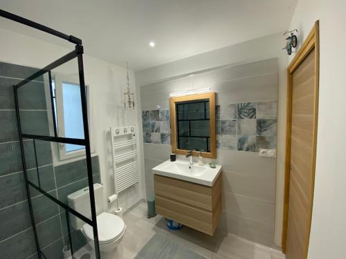 a bathroom with a sink and a toilet and a shower at La Note Bleue - Chambres d'hôtes in Échillais