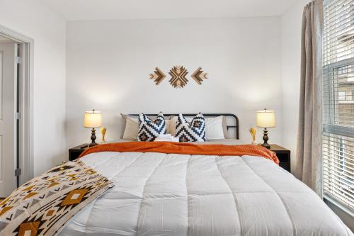 a bedroom with a large bed with two lamps at The Stockyard Retreat - Pool, Gym & Free Parking in Fort Worth