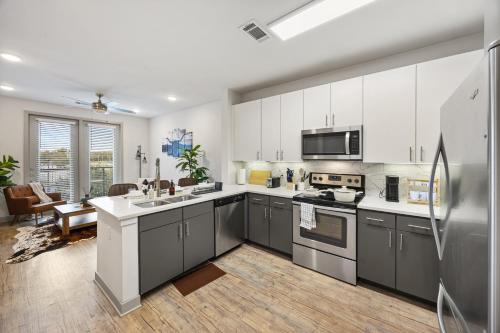 a kitchen with white cabinets and stainless steel appliances at The Stockyard Retreat - Pool, Gym & Free Parking in Fort Worth