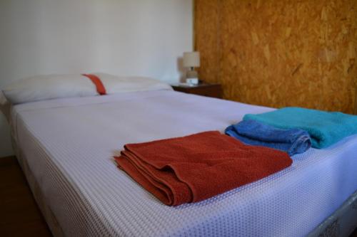 two towels sitting on top of a white bed at Complejo Orejano in Mercedes