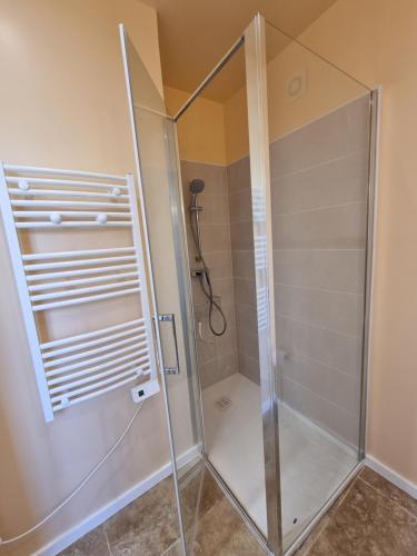 a shower with a glass door in a bathroom at Gite du Bois de Lord in Grandham