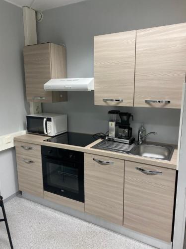 a kitchen with a sink and a microwave at Varastotie 1C in Ylivieska