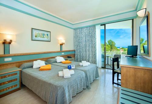 a hotel room with two beds and a television at Exagon Park in Can Picafort