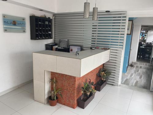 a kitchen with a counter with a brick fireplace at Hotel Baja South in La Paz