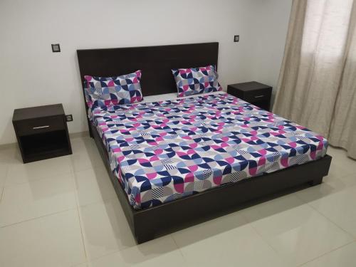 a bed in a room with two nightstands and a bed with aulic at VILLA Keur Diam in Somone