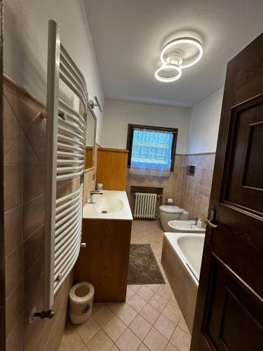 a bathroom with a sink and a tub and a toilet at Chalet Sofia in San Vito di Cadore