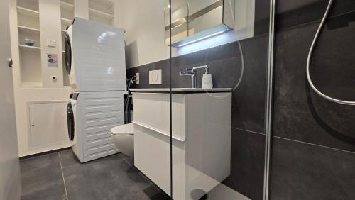 a white bathroom with a toilet and a sink at Apartment Local Uetendorf in Uetendorf