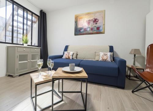 a living room with a blue couch and a table at le Gîte du Hibou in Rodemack