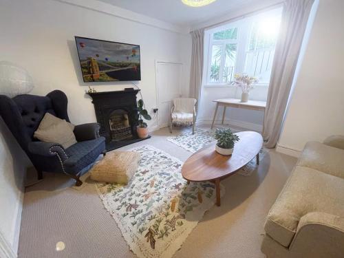 a living room with a couch and a table and a fireplace at Clifton Village Apartment in Bristol