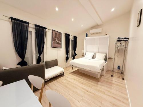 a bedroom with a bed and a couch and a table at Rempart du Chateau-SV86 StudioVincennes in Vincennes