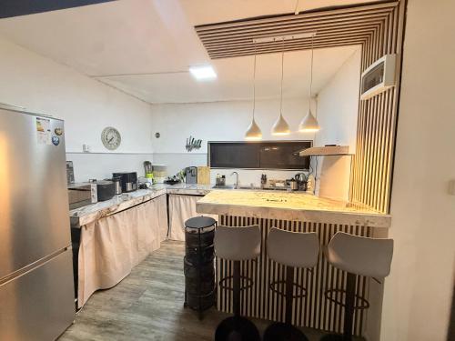 a large kitchen with a counter and a refrigerator at Fairyland room in Port Louis