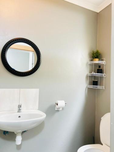 a bathroom with a sink and a mirror on the wall at Pwake Luna Guesthouse in Swakopmund