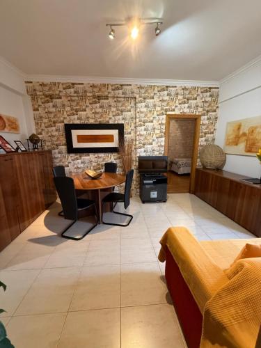 a living room with a table and a brick wall at My apartment in Sacavém in Sacavém