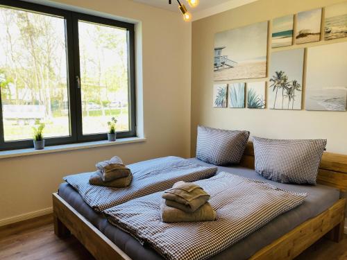 two beds in a room with towels on them at Ferienwohnung Auszeit in den Parkvillen Carlota und Candela Baabe in Baabe