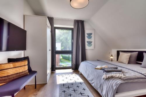 a bedroom with a large bed and a window at Ferienhaus Backsteinquartier D in Putbus mit Sauna und Kamin in Putbus
