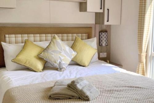 a bed with a towel on top of it at Luxury caravan-Sleeps 6- Pets Ok-Site Pool in Hunstanton