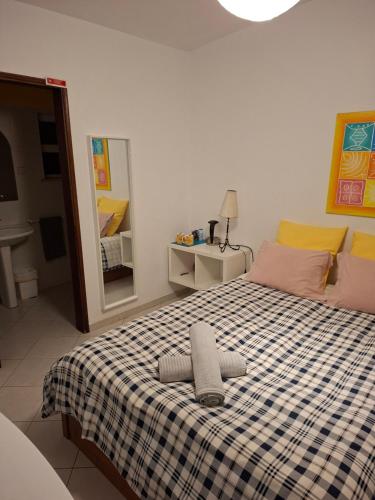 a bedroom with a bed with a checkered blanket at Eucalipto in Faro