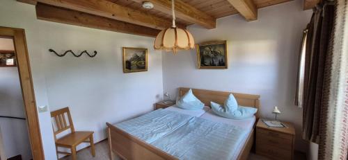 a small bedroom with a bed and a chair at Ferienwohnung Diechtler inkl. Chiemgaukarte in Ruhpolding