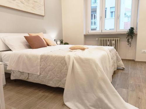 a bedroom with a large white bed with white sheets at Quick Home - Edera in Biella