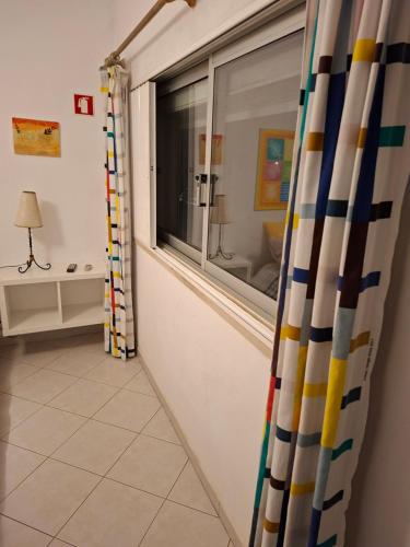 a room with a window and a tiled floor at Eucalipto in Faro