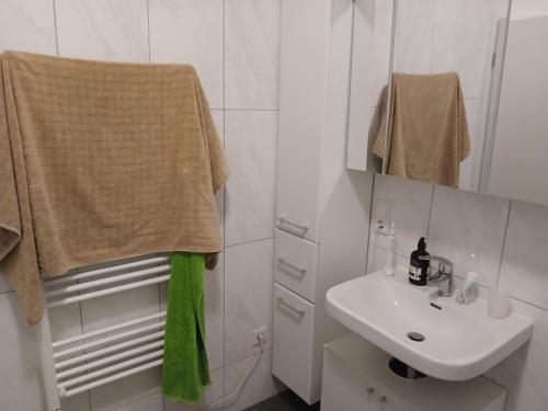 a white bathroom with a sink and a mirror at Wohnen am Schliestedter Bach b in Schöppenstedt