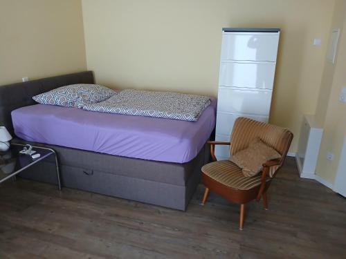 a small bedroom with a bed and a chair at Wohnen am Schliestedter Bach b in Schöppenstedt
