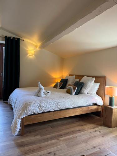a bedroom with a bed with two stuffed animals on it at le moulin de l oliveraie in Blausasc
