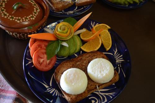 a blue plate with eggs on top of a sandwich at La Valise Los Cabos in Boca de la Vinorama