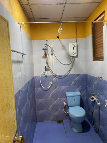 a bathroom with a blue toilet and a shower at DEMITHA guest in Ranna