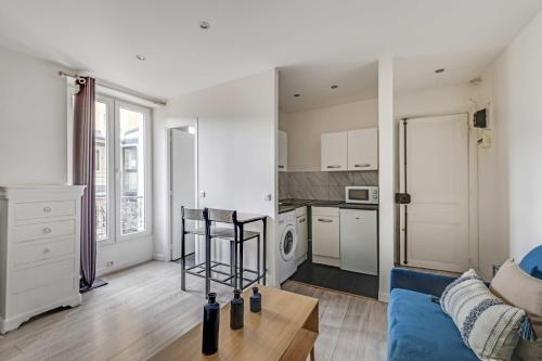 a living room with a blue couch and a kitchen at Cosy Studio - 2P- Clichy in Clichy