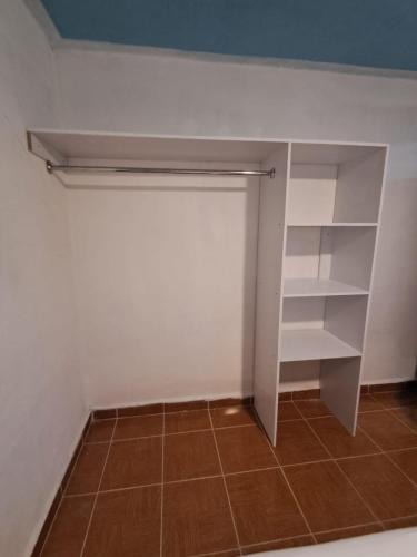 a closet with white shelves and a tile floor at Depa Banthi in San Juan del Río