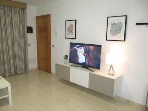 a living room with a flat screen tv on a cabinet at Apartamento " El Pueblo" in Mogán