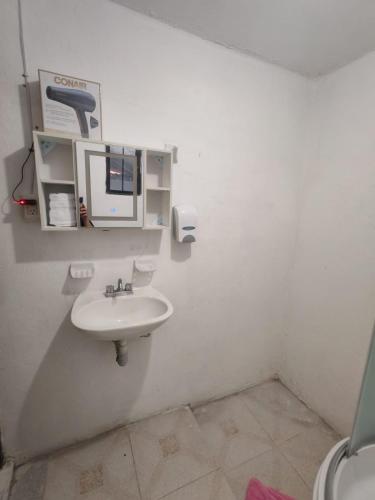 a white bathroom with a sink and a mirror at Depa Banthi in San Juan del Río
