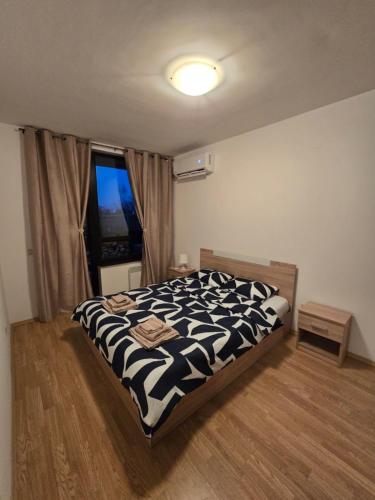 a bedroom with a black and white bed with a window at AspenValley Aprtment in Razlog