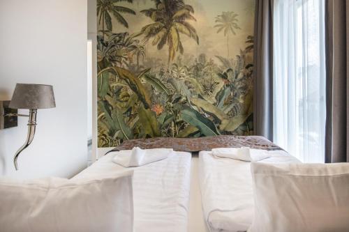 a bedroom with two beds and a wall mural at Flavius Spa Residence in Hévíz