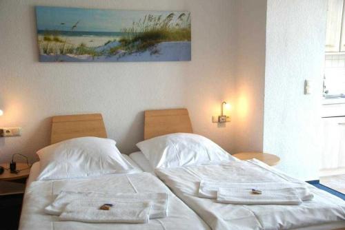 a bedroom with two beds and a painting on the wall at "Residenz Seeblick" Studio 23 mit seitlichem Ostseeblick in Ostseebad Sellin