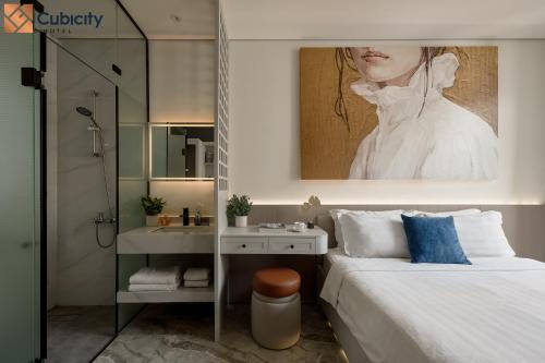 a bedroom with a bed and a sink and a painting at Cubicity Ton That Tung in Ho Chi Minh City